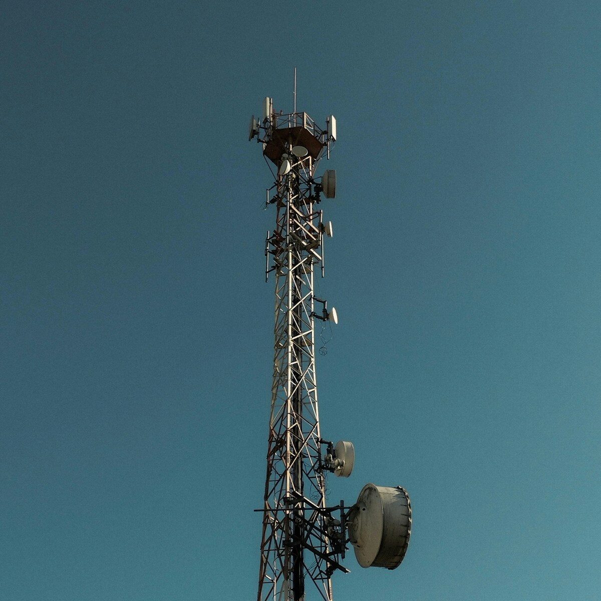 A tall cell tower against a clear blue sky